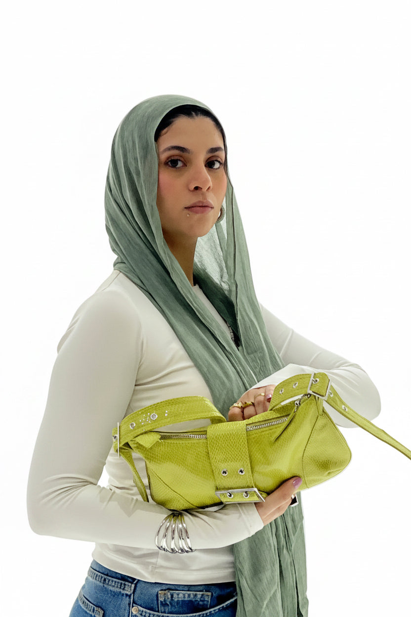 Woman holding a green bag against a white background